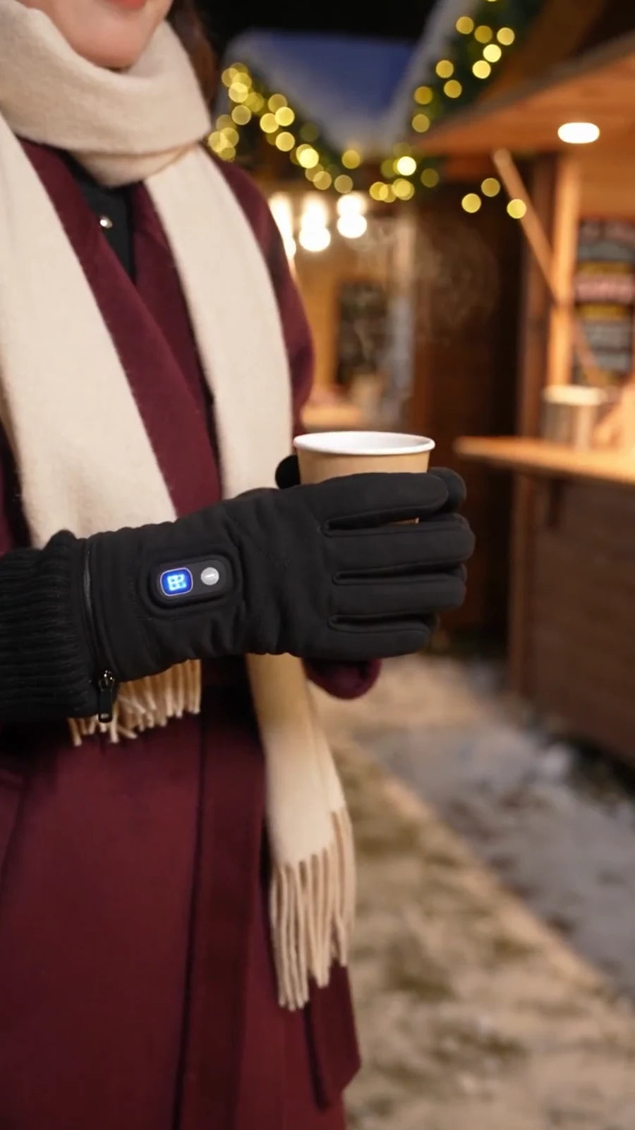 Gloved hands holding a warm drink at a winter market